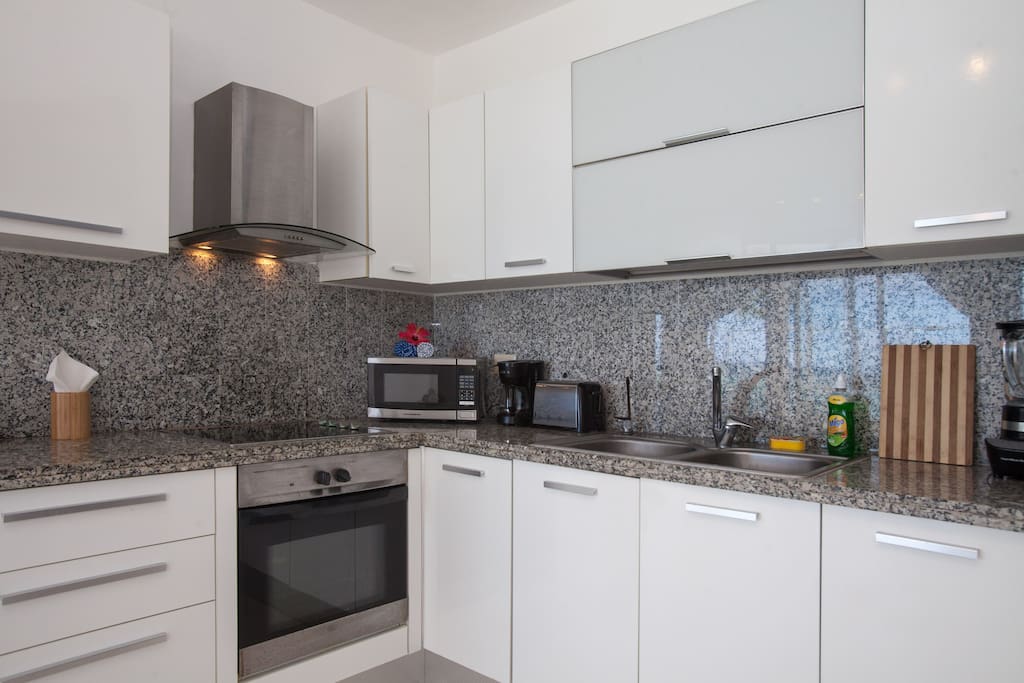 Airbnb Verified photo. White and shiny kitchen perfectly fits the whole beautiful design of this apartment. You can cook your favorite dishes here.