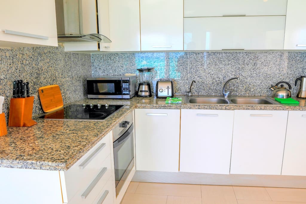 Airbnb Verified photo. White and shiny kitchen perfectly fits the whole beautiful design of this apartment. You can cook your favorite dishes here - it's a full-equipped, spacious kitchen