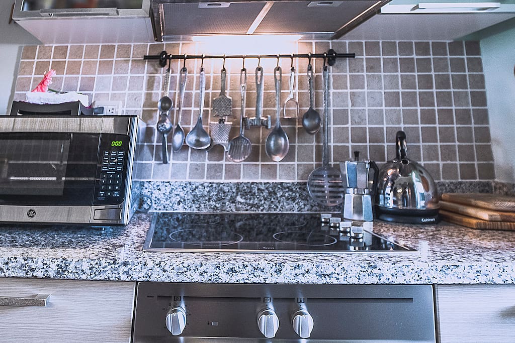 A fully-equipped kitchen features everything you might need: a microwave oven, coffee maker, teapot and kitchenware.
