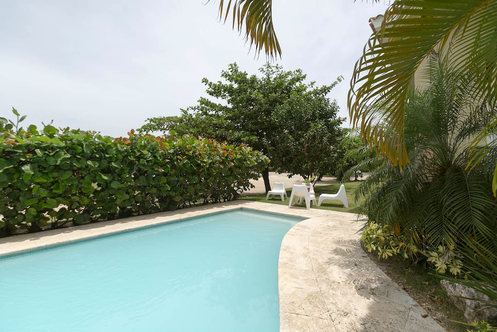 Jump into the cool pool right near the apartment, chill out near the pool on white cozy chaise lounges