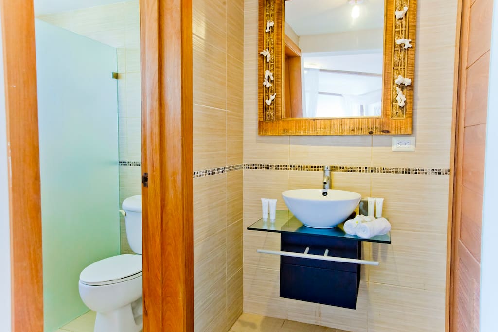 Airy and bright bathroom where you can take a shower after a long day on the beach.