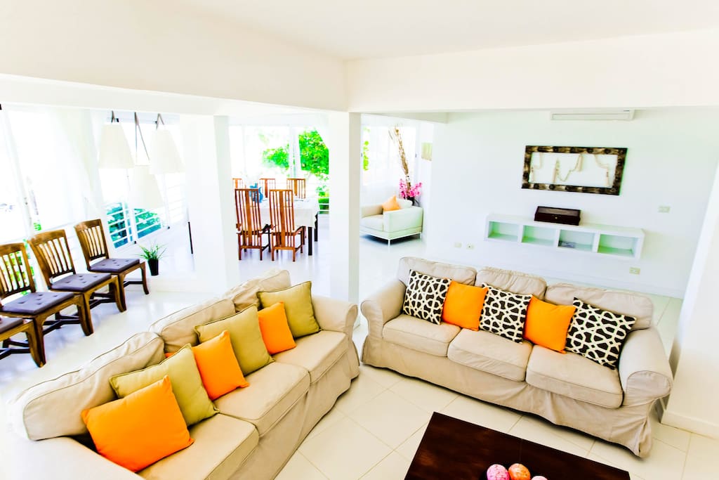 Amazing room with bright colors, comfortable sofas and panoramic windows overlooking the beach.