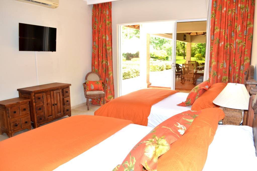 Another cozy bedroom with 2 beds and a flat-screen TV. Sliding doors lead to the patio where you can relax.