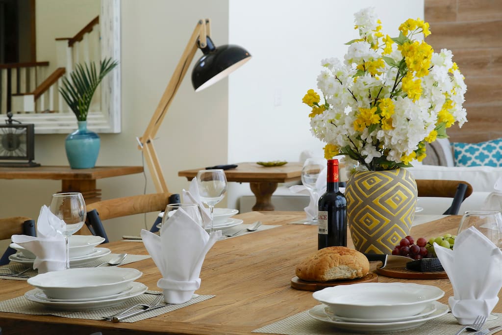 The dining area features a large table with utensils.