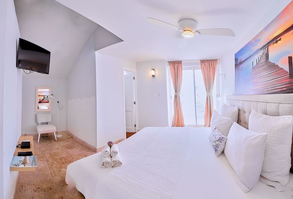 This bright bedroom has all you may need for a comfortable stay: ceiling fan, cable TV, closet and an en-suite bathroom with essential amenities