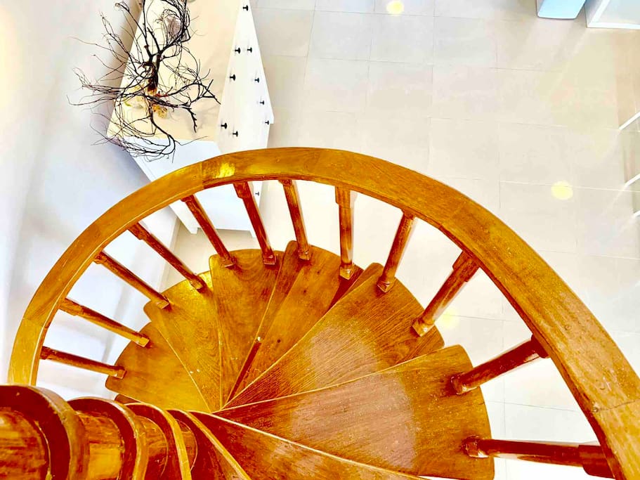 A wooden spiral staircase adds a special charm to the cozy apartment.