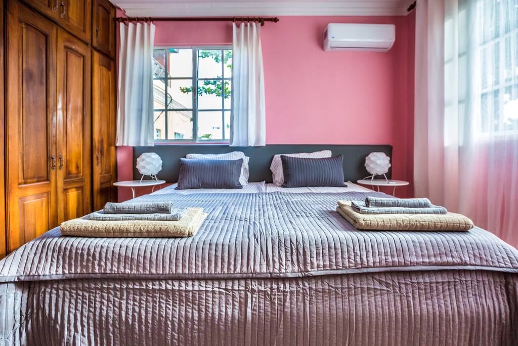 Rose room. Comfortable, wonderful, new, super king size, square, light, wooden bed. Bed size 200 cm x 200 cm. It can be divided by two single. Fresh linen. A set of fresh towels is provided so that you can sleep well and enjoy your stay. Every room has a spacious closet so you can store your things. Lamps, ceiling fan, and air conditioner in every room will make your stay comfortable and enjoyable