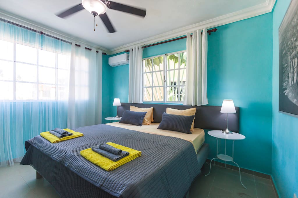 Turquoise Master bedroom. Comfortable, super king size bed, fresh linen. A kit of fresh towels. Here, you can sleep well and enjoy your stay. Every room has a spacious closet so you can store your belongings. Lamps, ceiling fan, and air conditioner in every room will make your stay comfortable and enjoyable