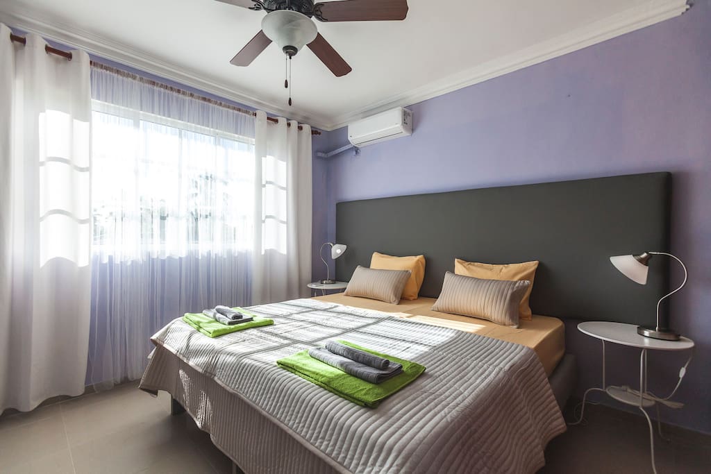 Lilac room - another shot in the morning. Comfortable, super king size bed (200x200 cm). It can be divided into two singles. Fresh linen. A kit of fresh towels so that you can sleep well and enjoy your stay. Every room has a spacious closet so you can store your things. Lamps, ceiling fan, and air conditioner in every room will make your stay comfortable and enjoyable